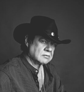 A man wearing a cowboy hat and looking at the camera.